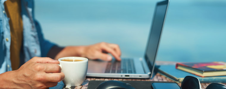 man working remotely from beach