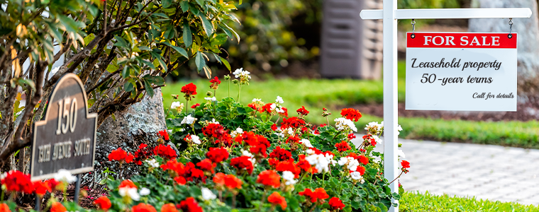 downtown beach city town with garden flowers and for sale real estate sign